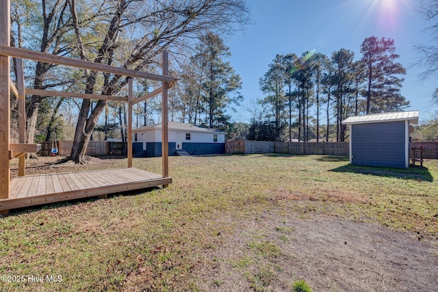 view of yard with a wooden deck and a storage shed