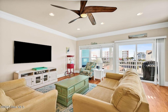 living room featuring hardwood / wood-style floors, ceiling fan, and ornamental molding