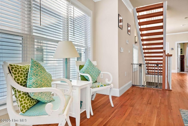 living area featuring hardwood / wood-style flooring and crown molding