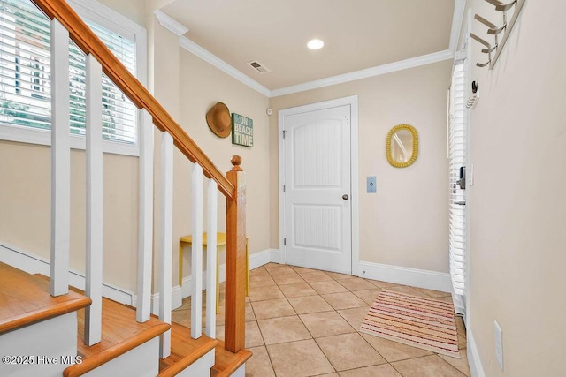 foyer entrance featuring light tile patterned floors and crown molding