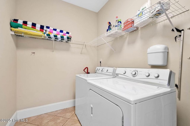 laundry area with washer and dryer and light tile patterned floors