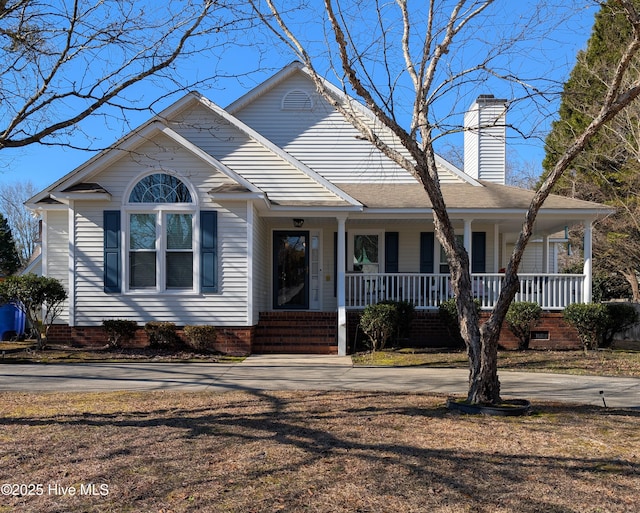 view of front facade featuring crawl space, covered porch, driveway, and a chimney