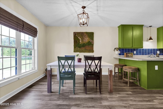 dining room with dark hardwood / wood-style flooring, a chandelier, a textured ceiling, and sink