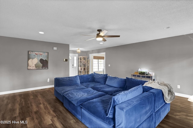 living room with ceiling fan, dark wood-type flooring, and a textured ceiling