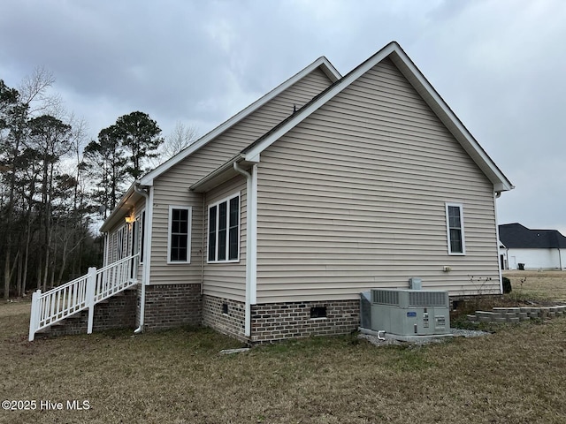 view of home's exterior with a lawn and central air condition unit