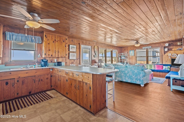 kitchen featuring wood walls, kitchen peninsula, sink, and wood ceiling