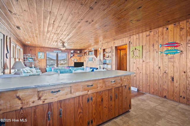 kitchen with ceiling fan, wooden ceiling, and wood walls