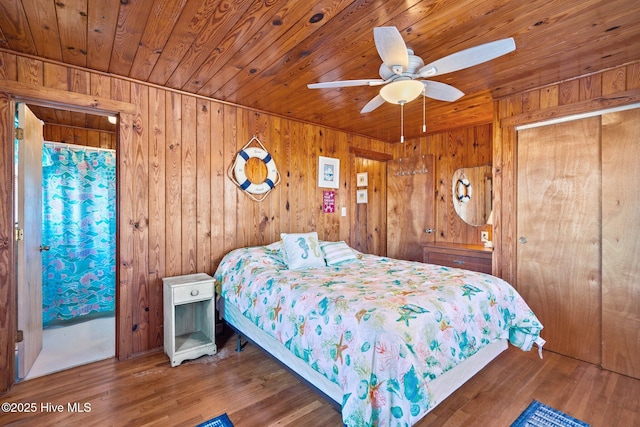 bedroom featuring dark hardwood / wood-style floors, ceiling fan, and wood walls