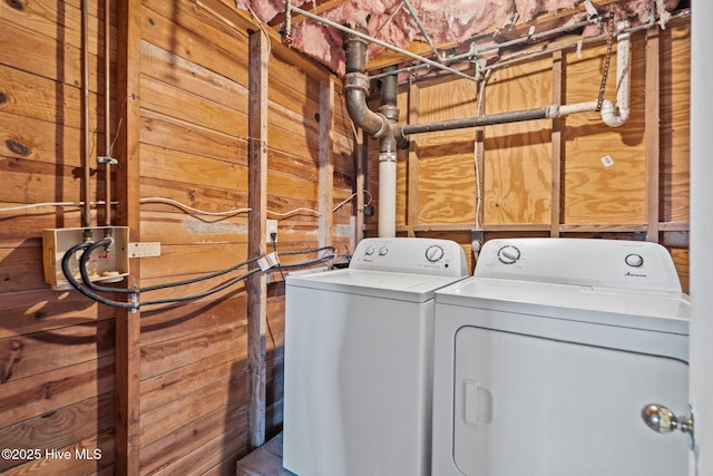 washroom with wood walls and washer and clothes dryer