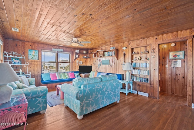 living room featuring hardwood / wood-style floors, wood walls, ceiling fan, built in features, and wood ceiling