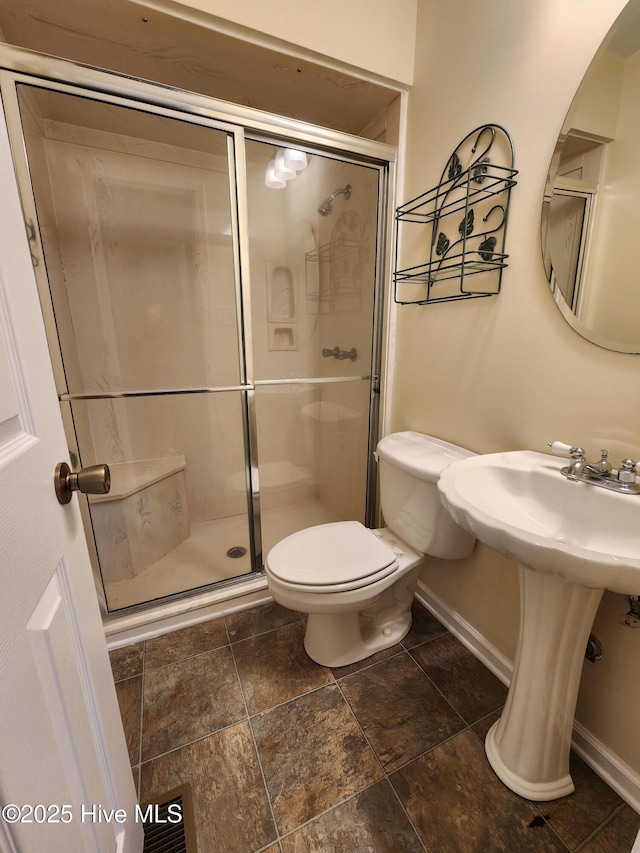 bathroom with toilet and a shower with shower door