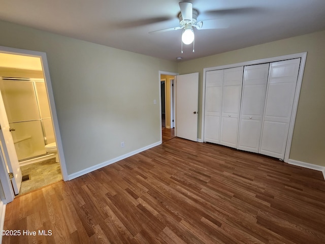 unfurnished bedroom with ensuite bath, ceiling fan, a closet, and wood-type flooring