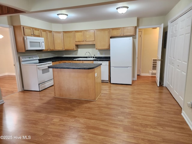 kitchen featuring a center island, light brown cabinets, white appliances, sink, and light wood-type flooring