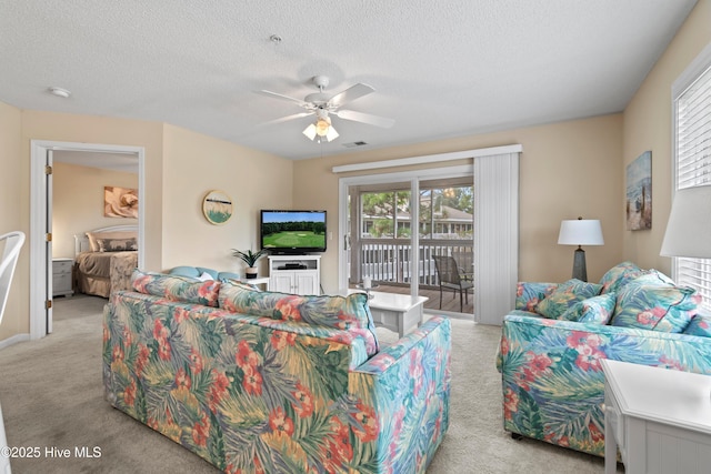 carpeted living room with ceiling fan and a textured ceiling