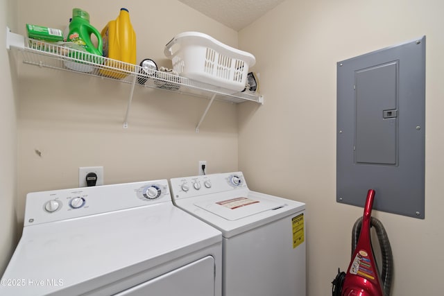 laundry room featuring washer and clothes dryer, a textured ceiling, and electric panel