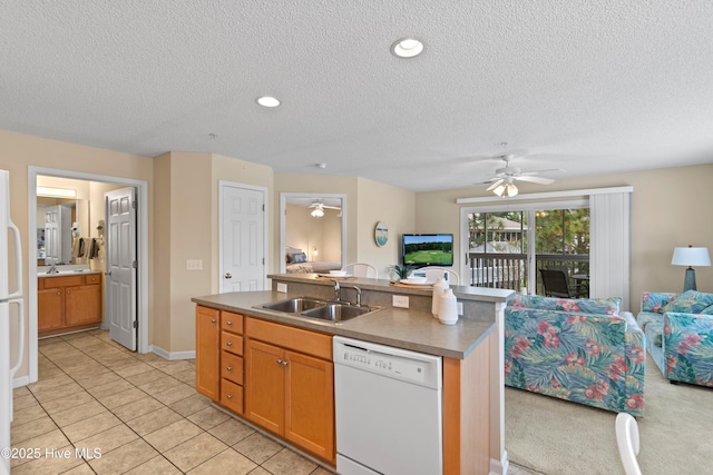 kitchen featuring light tile patterned floors, a kitchen island with sink, white dishwasher, a textured ceiling, and sink