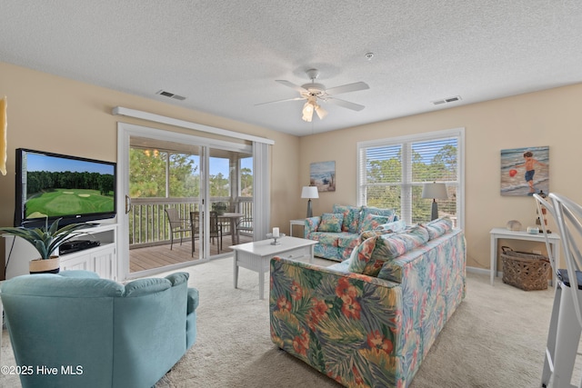 carpeted living room with ceiling fan and a textured ceiling