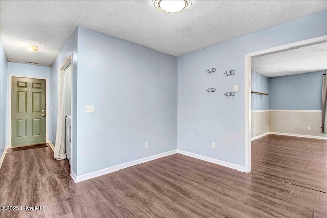 empty room featuring dark hardwood / wood-style flooring and a textured ceiling