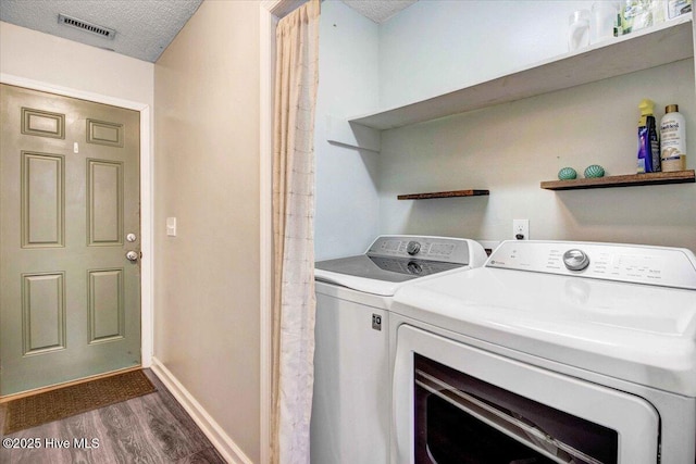 washroom featuring washer and dryer, a textured ceiling, and dark wood-type flooring