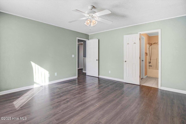 unfurnished bedroom with a textured ceiling, connected bathroom, ceiling fan, and dark wood-type flooring