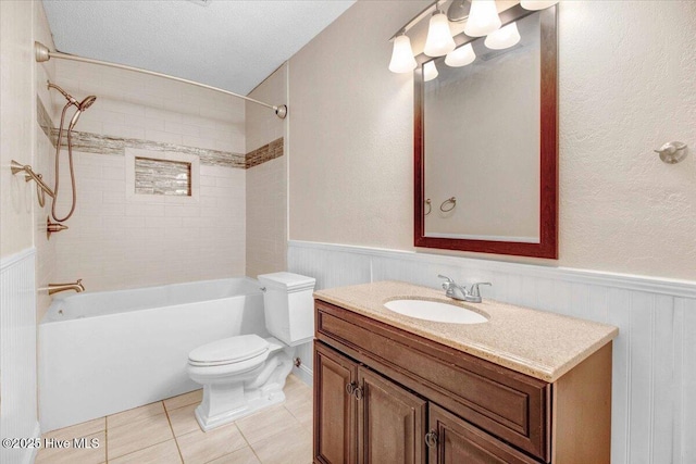 full bathroom with tile patterned flooring, a textured ceiling, toilet, vanity, and tiled shower / bath