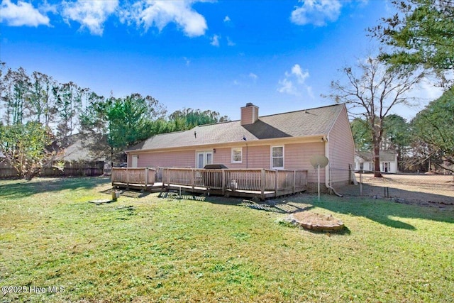 back of property featuring a lawn and a wooden deck