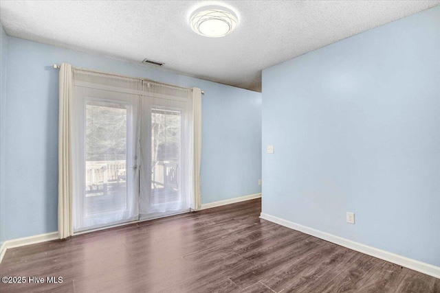 unfurnished room with dark hardwood / wood-style flooring and a textured ceiling