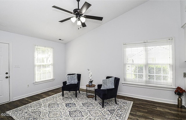 living area featuring dark hardwood / wood-style flooring, vaulted ceiling, ceiling fan, and a healthy amount of sunlight