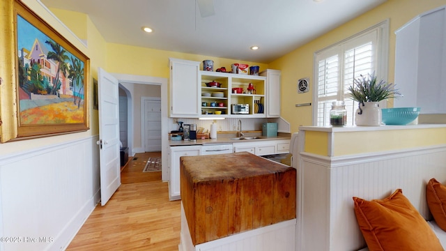 kitchen with dishwasher, light wood-type flooring, white cabinetry, and sink