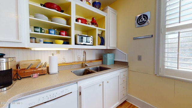 kitchen featuring white cabinets, dishwasher, and sink