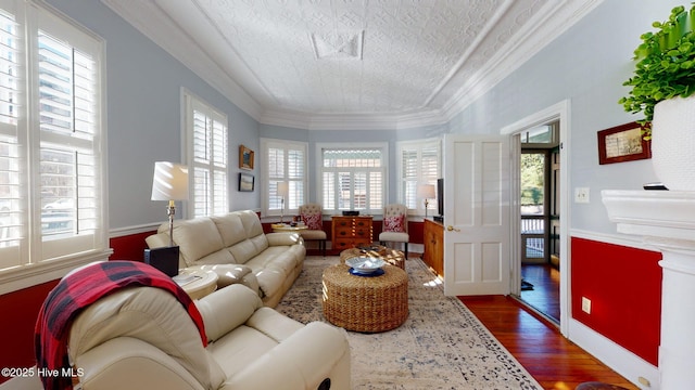 living room featuring dark wood-type flooring, a textured ceiling, and ornamental molding