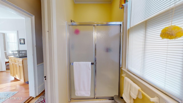 bathroom with hardwood / wood-style floors and an enclosed shower