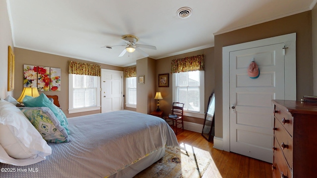 bedroom featuring hardwood / wood-style floors, ceiling fan, and crown molding