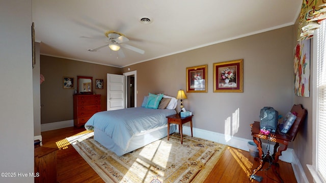 bedroom with hardwood / wood-style floors, ceiling fan, and ornamental molding