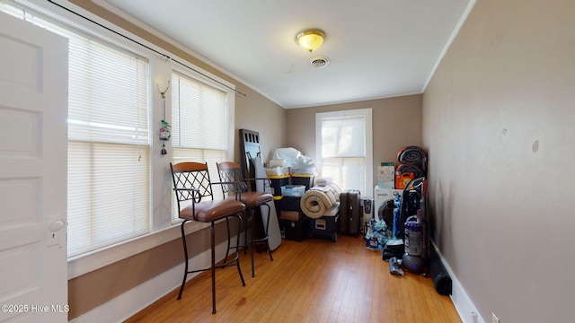 office with light hardwood / wood-style floors and crown molding