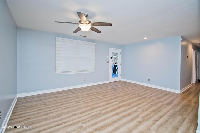 spare room with light wood-type flooring and ceiling fan