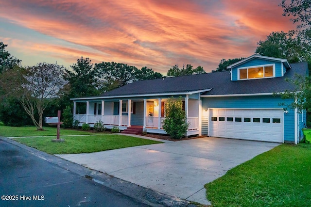 view of front of property with a yard, a porch, and a garage