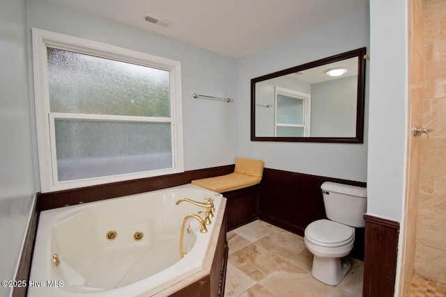 bathroom featuring a tub to relax in and toilet