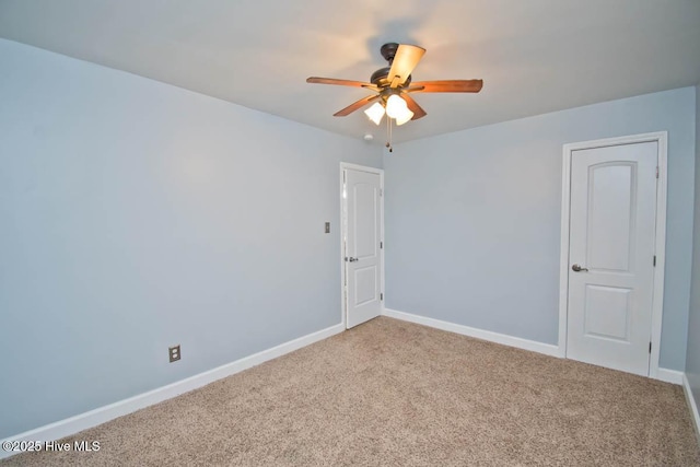 carpeted spare room with ceiling fan