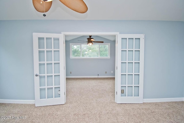 carpeted empty room with french doors, vaulted ceiling, and ceiling fan