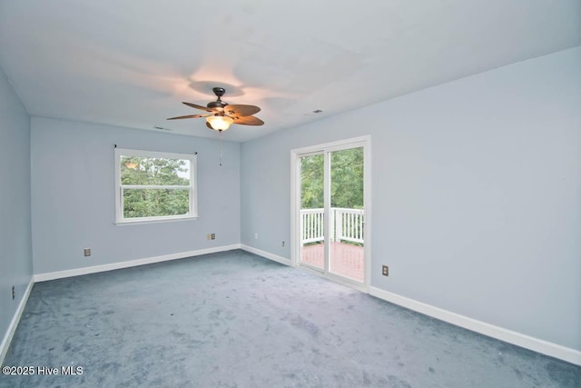 carpeted spare room featuring ceiling fan