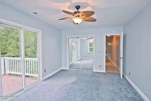 unfurnished bedroom with access to exterior, ceiling fan, a closet, and carpet floors