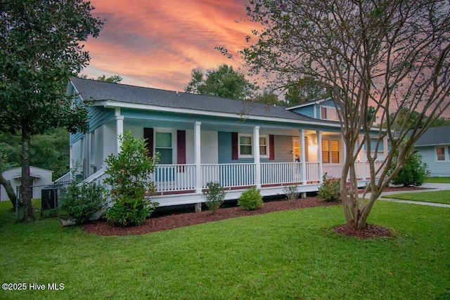 view of front of property with a porch and a lawn