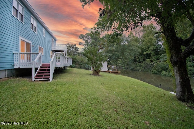 yard at dusk featuring a wooden deck