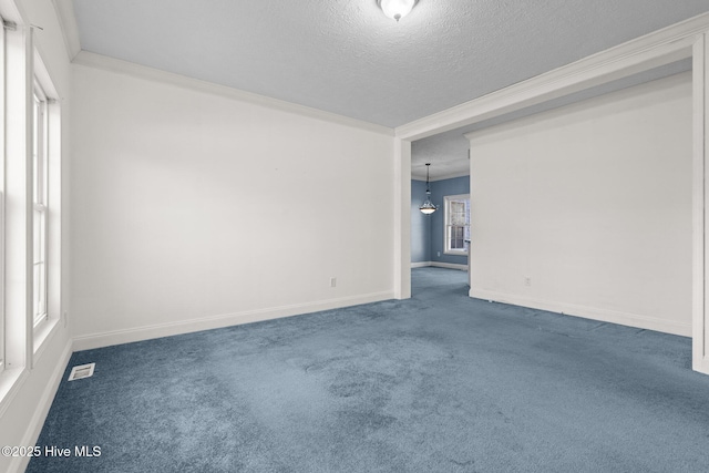 carpeted empty room with a textured ceiling and ornamental molding