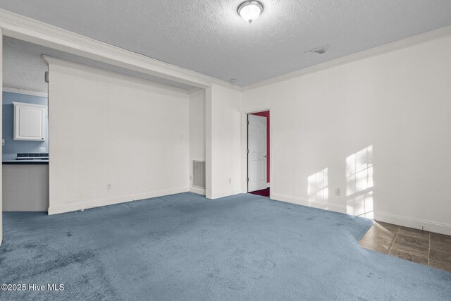 carpeted spare room featuring a textured ceiling and ornamental molding