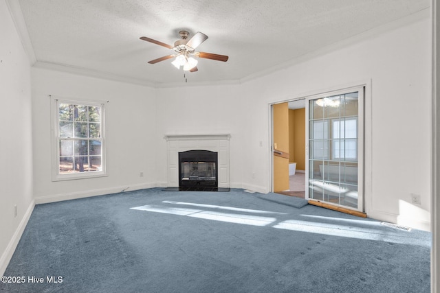 unfurnished living room featuring ceiling fan, carpet floors, a textured ceiling, and ornamental molding