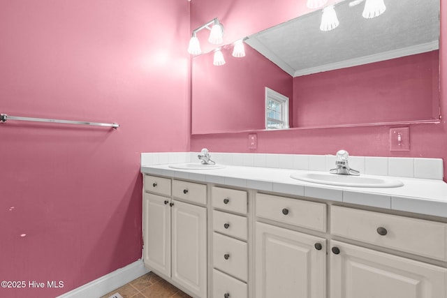 bathroom featuring tile patterned floors, crown molding, vanity, and a textured ceiling