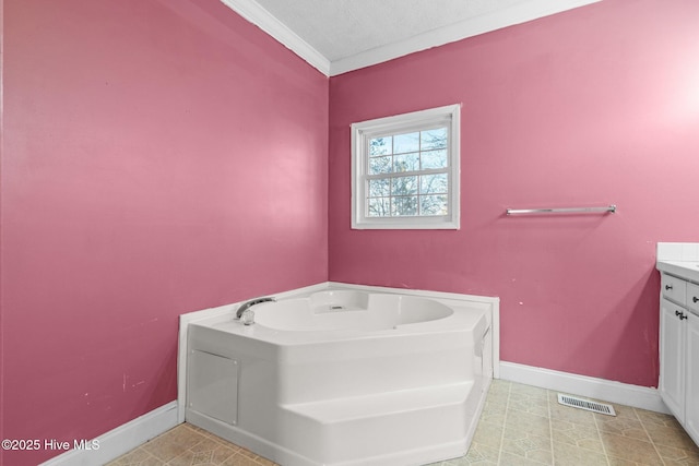 bathroom with a washtub, crown molding, a textured ceiling, and vanity