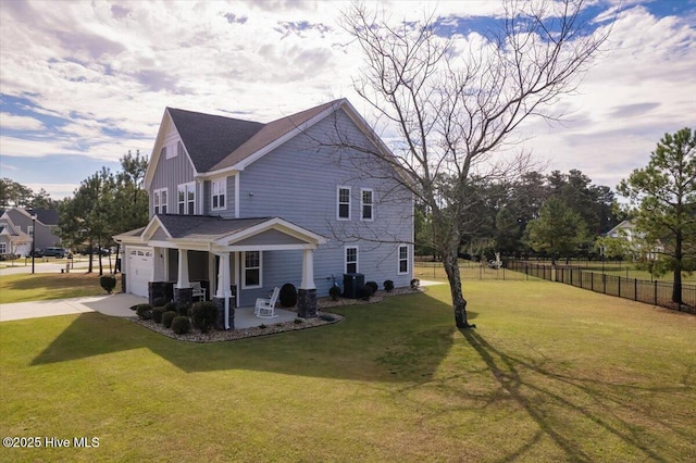 view of home's exterior with covered porch, a garage, central AC, and a yard